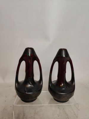 deux vases posés sur un socle transparent, sur une surface blanche