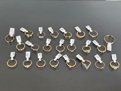 a bunch of gold and silver rings with tags on them