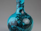 blue glass vase with a black and white design on it