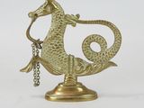 brass seahorse figurine with a chain on a white background
