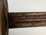 a close up of a sword on a white surface