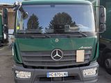 un camion vert garé devant un immeuble