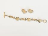 une photo représentant un bracelet en or et deux breloques sur un fond blanc