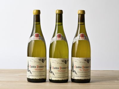 trois bouteilles de vin posées sur une table en bois