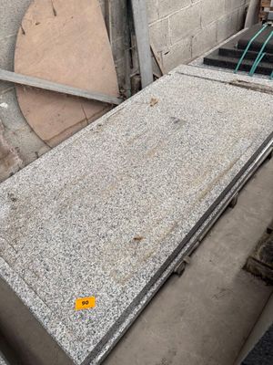 a pile of granite on the ground next to a building