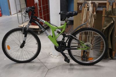 un vélo qui se trouve dans une pièce, à côté d'une pile de cartons