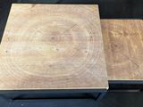 a pair of wooden tables with metal legs on a black background