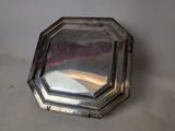 a silver plate with a mirror on it on a table