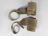 deux paires de ciseaux et une paire de menottes posées sur une surface blanche