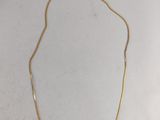 un collier plaqué or sur un fond blanc