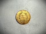 a close up of a gold coin on a white surface