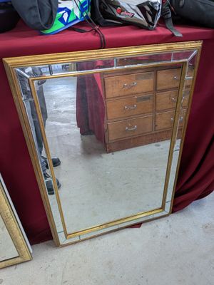 two mirrors sitting on a table with a red table cloth