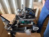 un homme debout à côté d'un carton contenant du matériel électronique