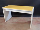 a small white table with a yellow top on a carpeted floor