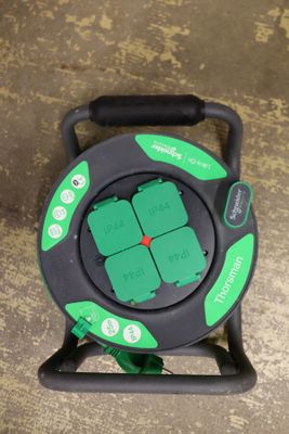 a close up of a green and black hose on top of a floor