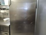 a silver refrigerator in a kitchen with a microwave on top of it