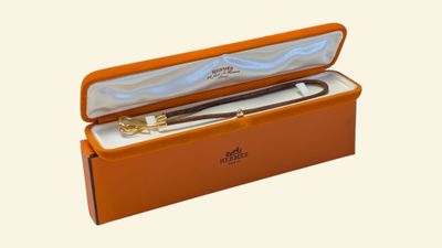 une boîte orange contenant un stylo, sur fond blanc