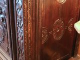 a wooden cabinet with carvings on it in a room