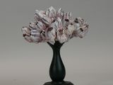 a black vase with a bunch of pink flowers in it