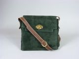 un sac à bandoulière vert en daim, muni d'une bandoulière en cuir marron