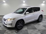 La Toyota RAV blanche est garée sur un sol en carrelage à damier.