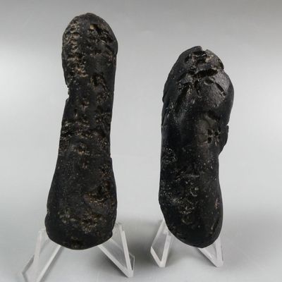 two pieces of black stone on clear acrylic stands