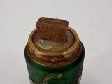 a small green jar with a piece of bread in it
