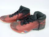 une paire de chaussures de basket rouges avec des lacets noirs sur une semelle blanche