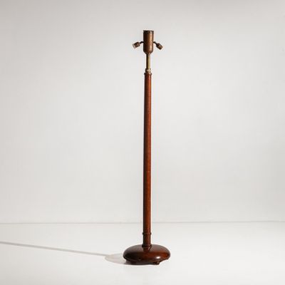 a wooden floor lamp with a metal pole on top of it