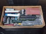 une boîte remplie de rails de train miniature et d'autres jouets