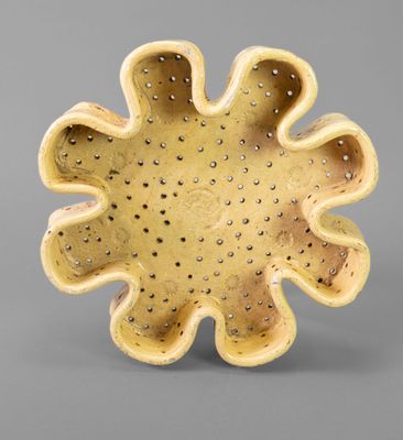 bowl shaped like a flower with holes in the center