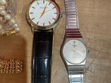 a couple of watches sitting on a table next to some beads