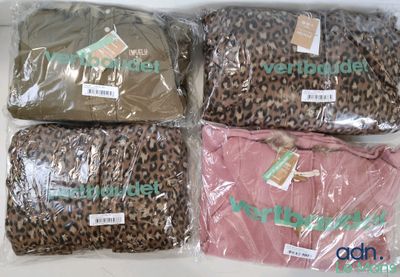 quatre sacs de vêtements sont emballés dans du plastique et posés sur une table