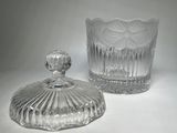 two clear glass jars with lids sitting on a white surface