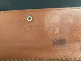 an image of a brown leather wallet with a small hole in the middle