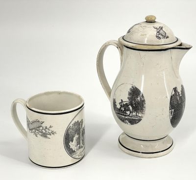 une cafetière blanche et noire à côté d'une tasse à café