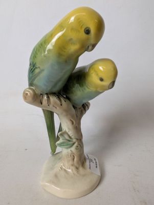 a figurine of two parrots sitting on a branch