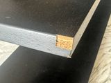 a close up of a black table with a wooden edge
