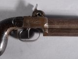 gros plan d'un pistolet sur une table à fond blanc