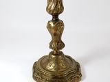 an antique brass candle holder on a white background
