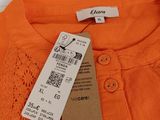 an orange shirt with a tag on the back of it