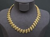 a close up of a mannequin with a gold necklace on it