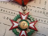 une médaille posée sur un ruban rouge, elle-même posée sur un morceau de papier