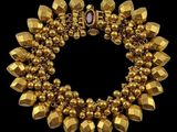 a close up of a gold bracelet on a black background