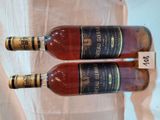 deux bouteilles de vin posées sur une table l'une à côté de l'autre