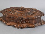 an old wooden box with carvings on it on a gray surface