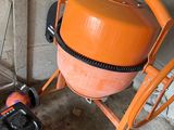 une bétonnière orange garée à côté d'une voiture bleue