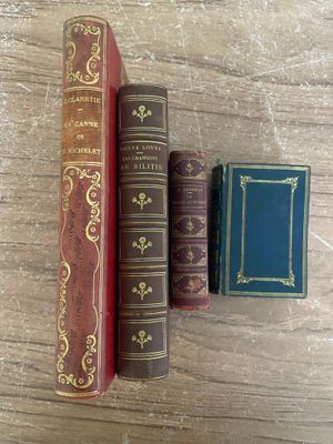 trois vieux livres posés les uns à côté des autres sur une table en bois