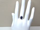 une main sur laquelle est passée une bague sertie d'une pierre bleue