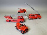 quatre camions de pompiers miniatures et un camion de pompiers posés sur une table